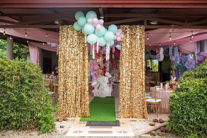 Entrada del evento con cortinas doradas y globos
