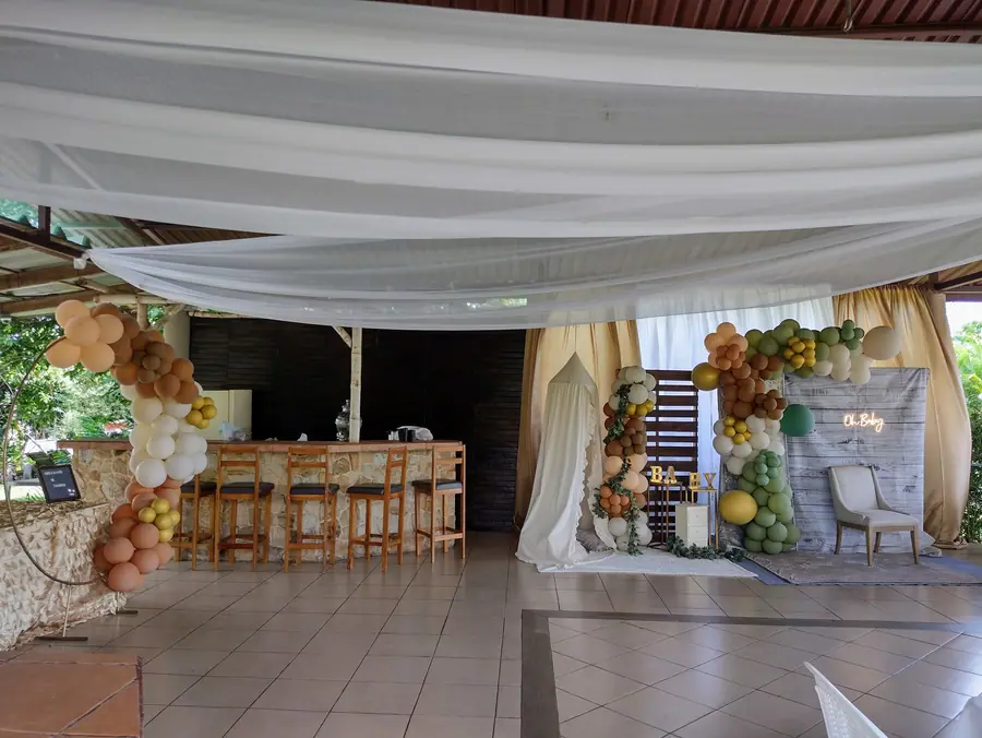 Rancho Bambú Lourdes montado para baby shower con cortinas blancas y arcos de globos
